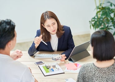 A woman discussing estate planning with a man and woman at a table - Legacy Law Centers