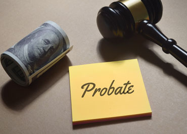 Probate written on paper with judge’s gavel and a roll of money, symbolizing the cost of probate - Legacy Law Centers