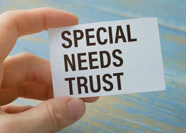 Person holding card with text special needs trust - Legacy Law Centers