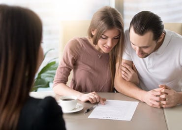 A man and woman sit at a table with papers, reading state Planning Strategies for Unmarried Partners - Legacy Law Centers