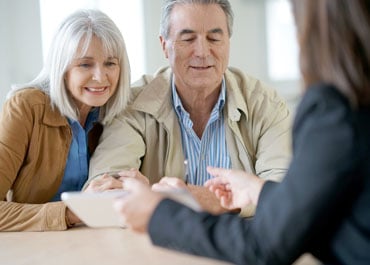 Elderly couple discussing estate planning at a table with a tablet - Legacy Law Centers